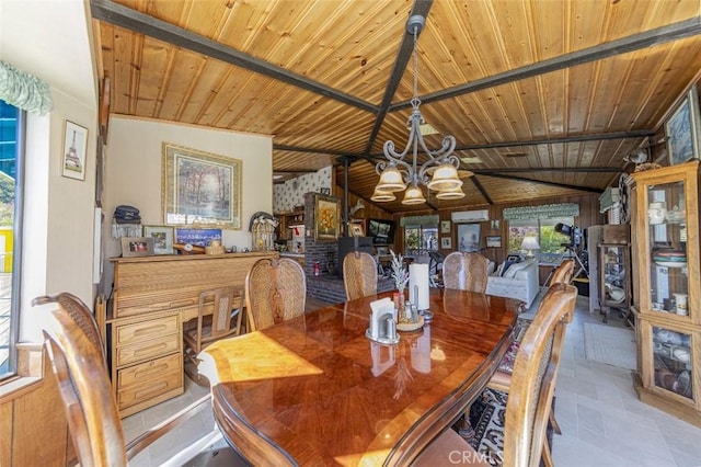 tiled dining space with a healthy amount of sunlight, lofted ceiling with beams, and wooden ceiling