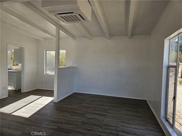 empty room with dark hardwood / wood-style flooring and beamed ceiling