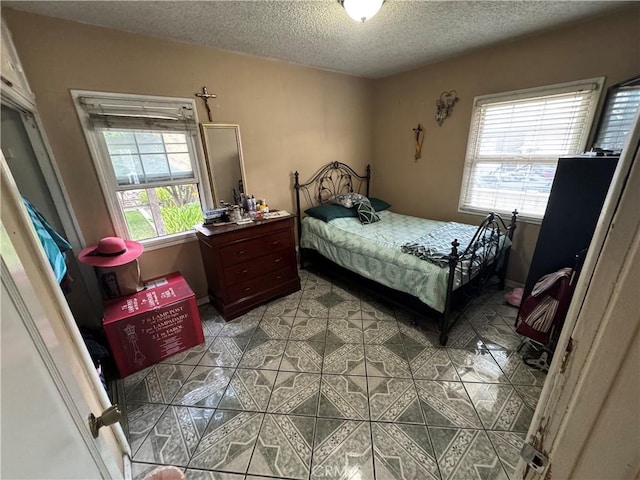 bedroom with light tile patterned flooring and a textured ceiling