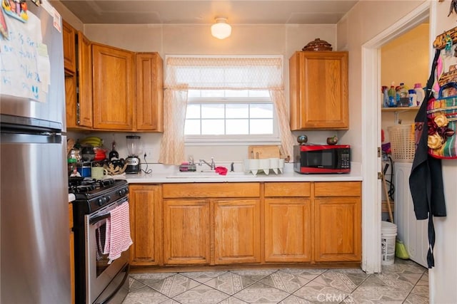 kitchen featuring light tile patterned floors, stainless steel appliances, and sink