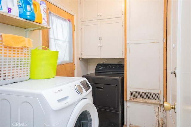 clothes washing area with washer and dryer and cabinets