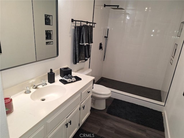 bathroom with hardwood / wood-style flooring, vanity, toilet, and walk in shower