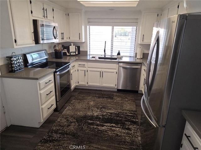 kitchen with dark hardwood / wood-style flooring, white cabinetry, sink, and appliances with stainless steel finishes