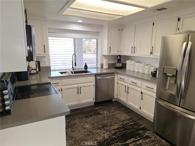 kitchen featuring stainless steel appliances, white cabinetry, and sink