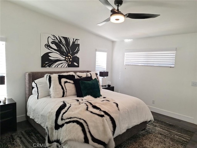 bedroom with ceiling fan, lofted ceiling, and dark wood-type flooring