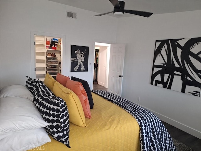 bedroom with wood-type flooring, a spacious closet, a closet, and ceiling fan