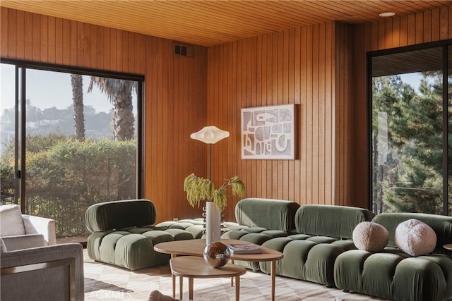 sitting room featuring wooden ceiling and wooden walls