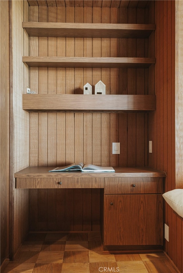 interior space featuring parquet flooring and wooden walls