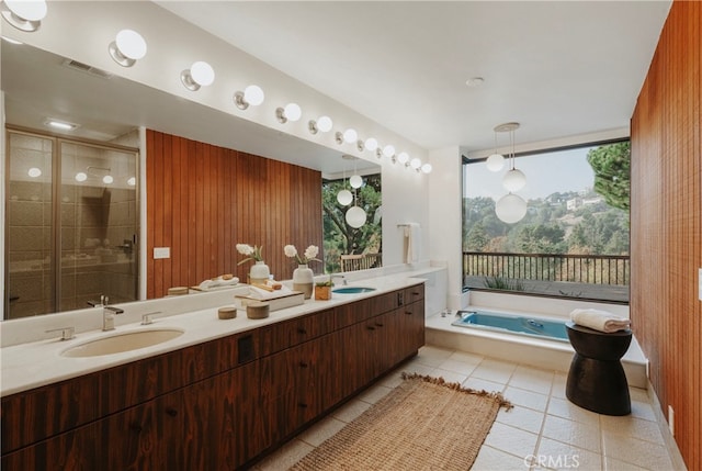 bathroom with tile patterned floors, vanity, wood walls, and shower with separate bathtub