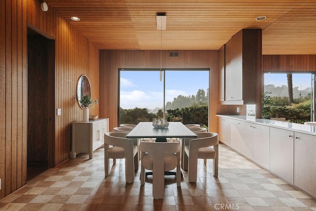 dining space featuring wood ceiling, plenty of natural light, and wood walls