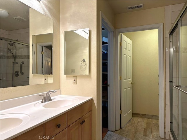 bathroom featuring hardwood / wood-style flooring, vanity, and an enclosed shower