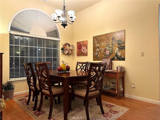 dining area featuring an inviting chandelier and hardwood / wood-style flooring