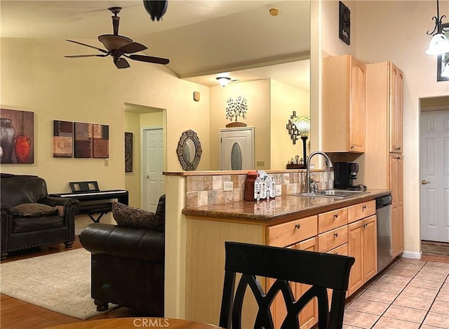 kitchen featuring sink, stainless steel dishwasher, ceiling fan, light tile patterned floors, and light brown cabinetry