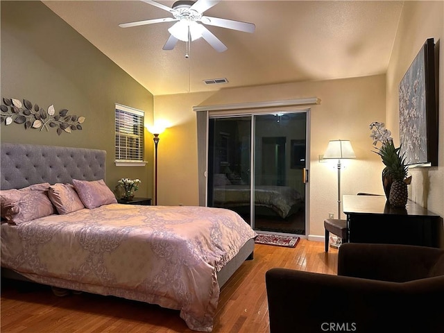 bedroom featuring ceiling fan, access to exterior, wood-type flooring, and lofted ceiling