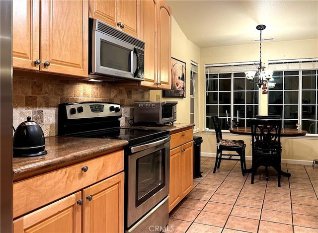 kitchen featuring decorative backsplash, stainless steel appliances, light tile patterned floors, decorative light fixtures, and an inviting chandelier