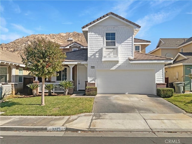 view of front of house with a front yard, concrete driveway, brick siding, and an attached garage