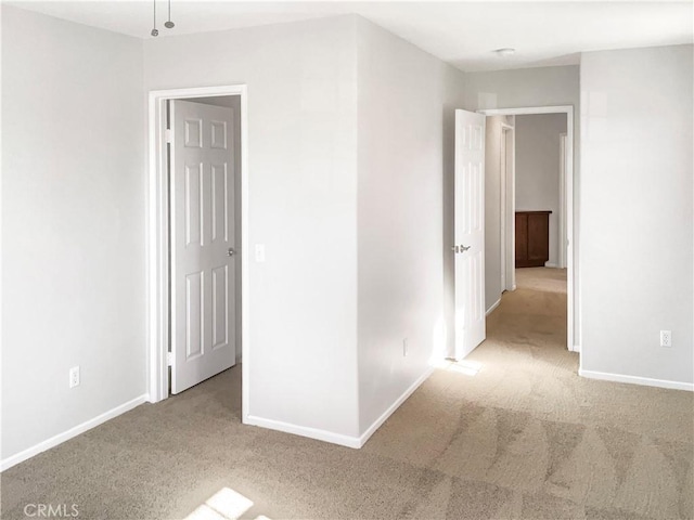 empty room with light carpet and baseboards