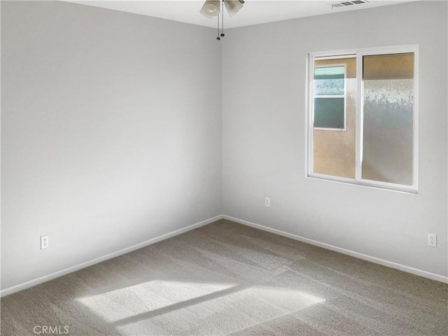 carpeted spare room featuring ceiling fan