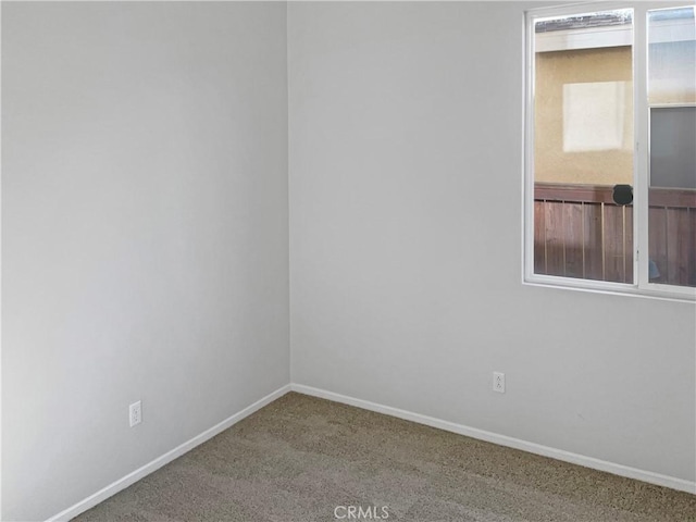 unfurnished room featuring carpet floors and baseboards