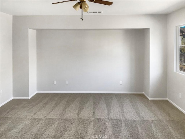 spare room with a ceiling fan, baseboards, visible vents, and carpet flooring