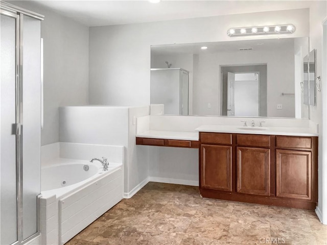 bathroom featuring vanity and independent shower and bath