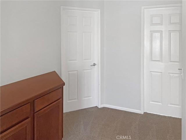 unfurnished bedroom featuring light colored carpet and baseboards