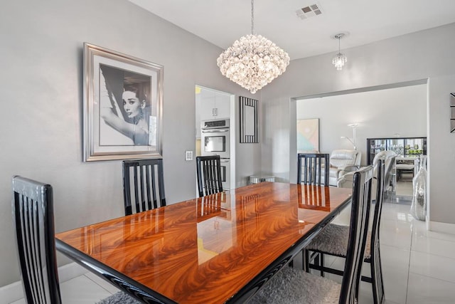 tiled dining space featuring an inviting chandelier