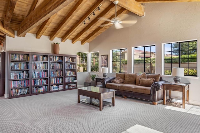 sitting room with ceiling fan, beam ceiling, carpet floors, and high vaulted ceiling