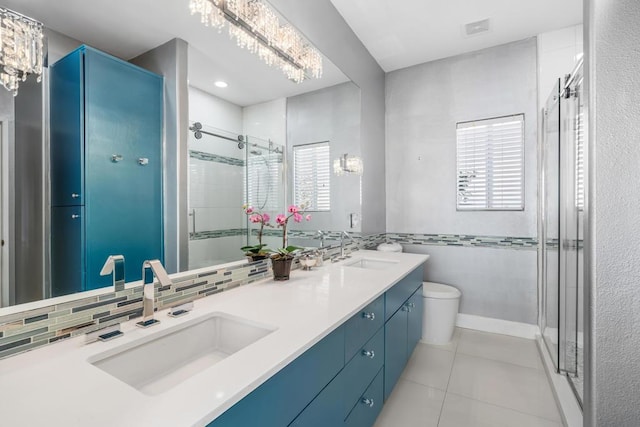 bathroom with tasteful backsplash, tile patterned floors, a wealth of natural light, and a notable chandelier