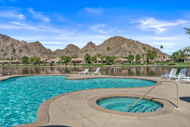 view of pool with a patio area, a water and mountain view, and a hot tub