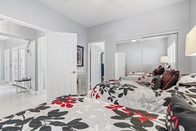 tiled bedroom featuring vaulted ceiling and a closet