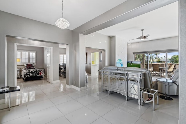 dining room with light tile patterned floors and ceiling fan with notable chandelier