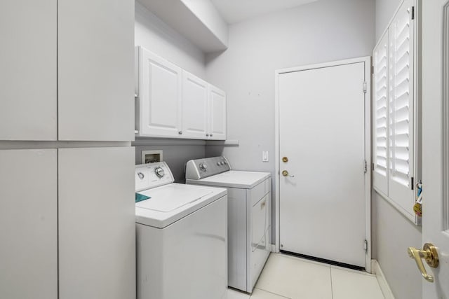 laundry room with cabinets, washing machine and dryer, and light tile patterned flooring