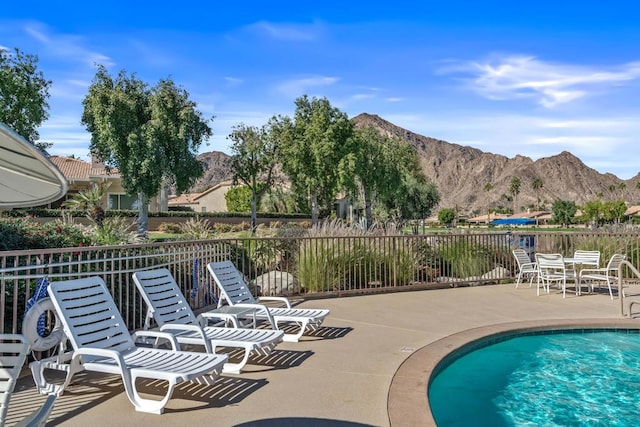 view of swimming pool featuring a mountain view and a patio