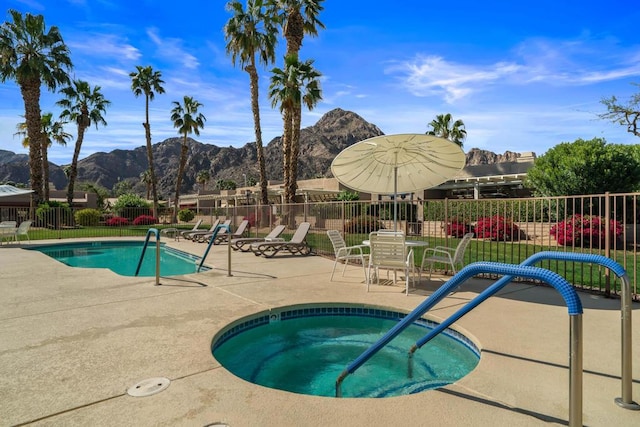 view of pool featuring a mountain view, a community hot tub, and a patio