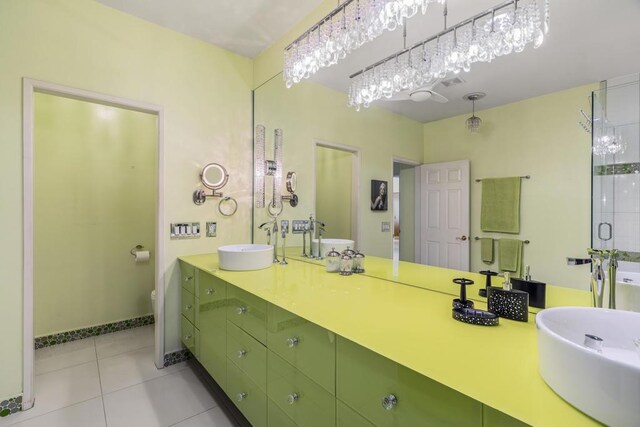 bathroom with tile patterned floors, vanity, toilet, and an enclosed shower