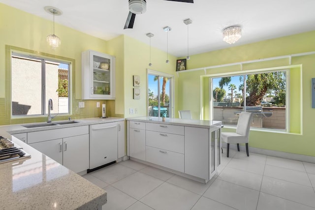 kitchen featuring white dishwasher, kitchen peninsula, white cabinetry, and hanging light fixtures