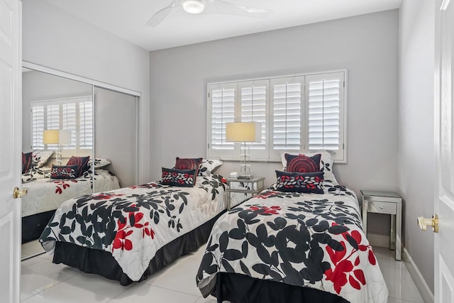 tiled bedroom with ceiling fan and a closet