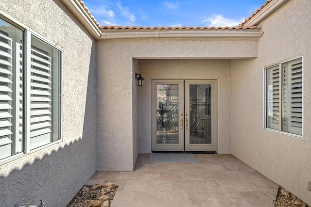 view of exterior entry with a patio