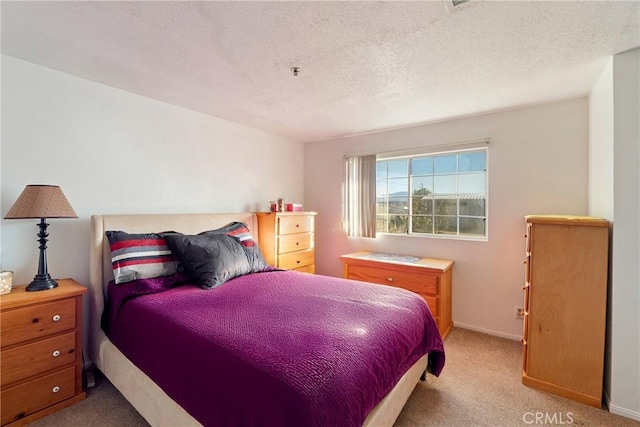 bedroom featuring a textured ceiling and light carpet