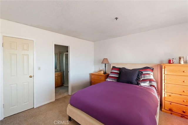 bedroom featuring light colored carpet and connected bathroom