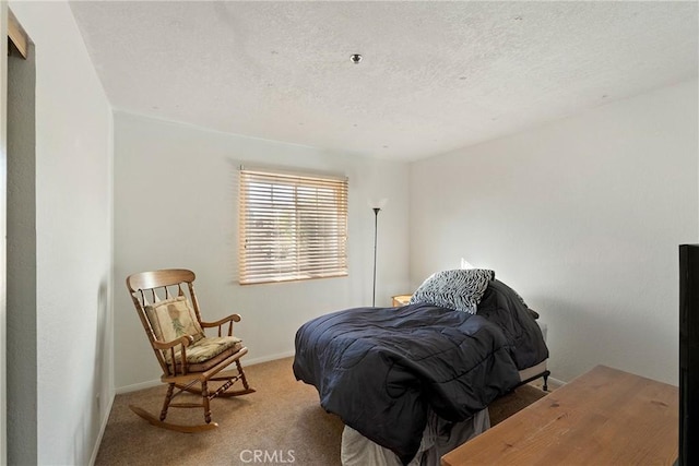 bedroom featuring carpet flooring and a textured ceiling