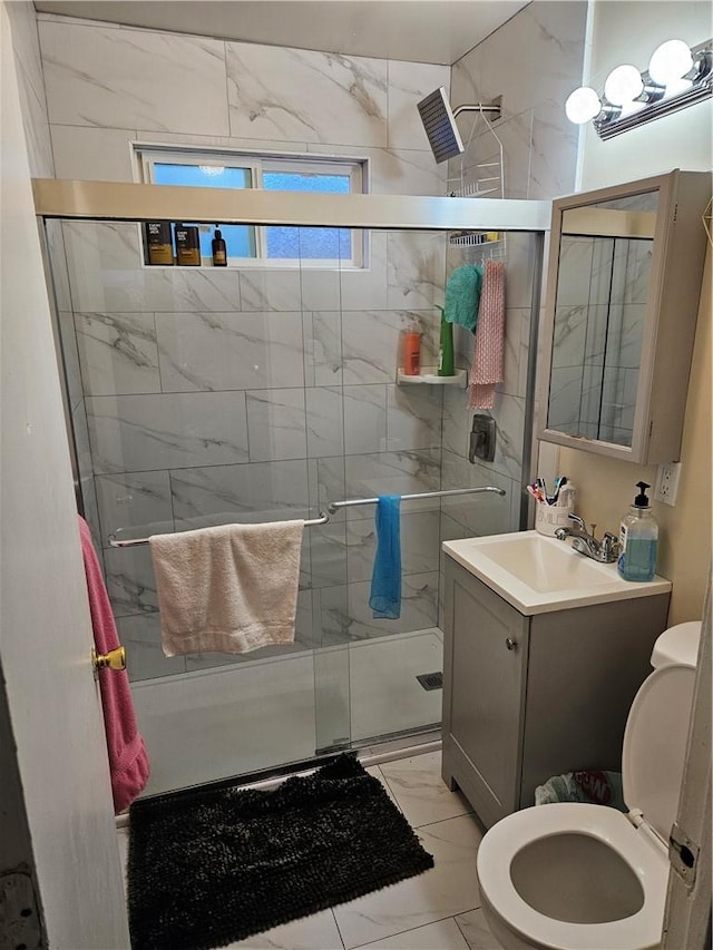 full bath featuring marble finish floor, toilet, vanity, and a stall shower