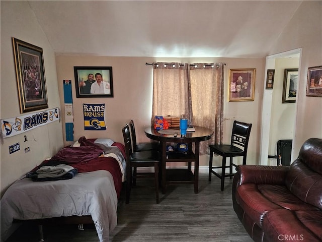 bedroom with lofted ceiling and dark wood-style floors