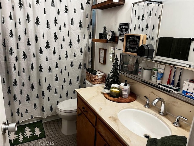 bathroom featuring tile patterned flooring, vanity, toilet, and walk in shower