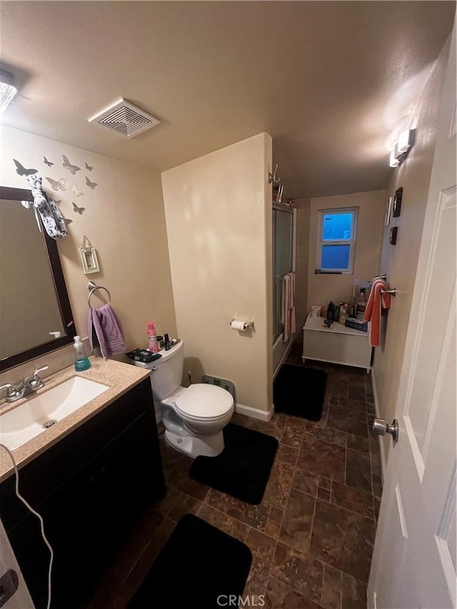 bathroom with vanity, toilet, and an enclosed shower