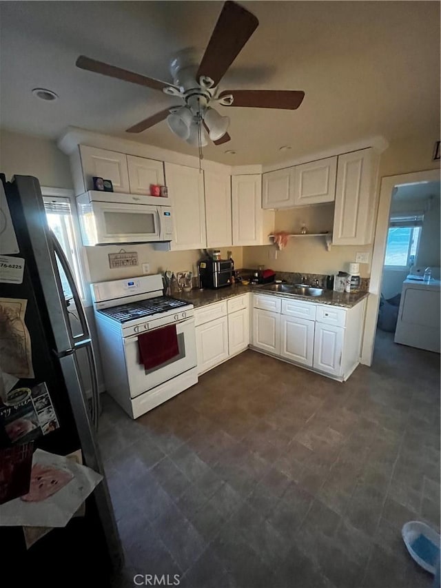 kitchen with ceiling fan, sink, washer / clothes dryer, white appliances, and white cabinets