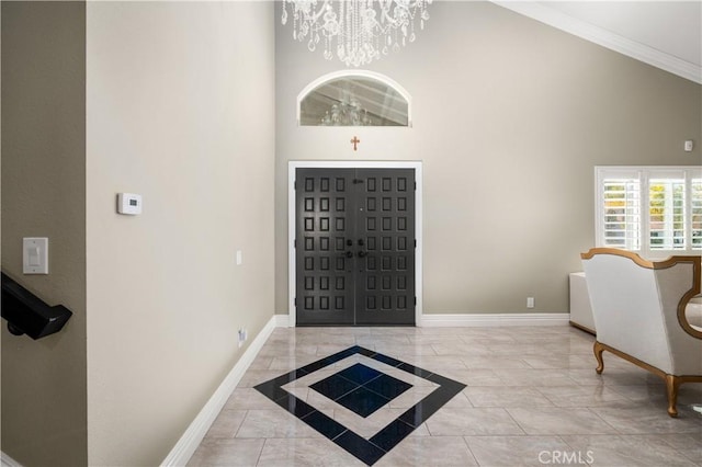 entryway with a notable chandelier, crown molding, and a towering ceiling