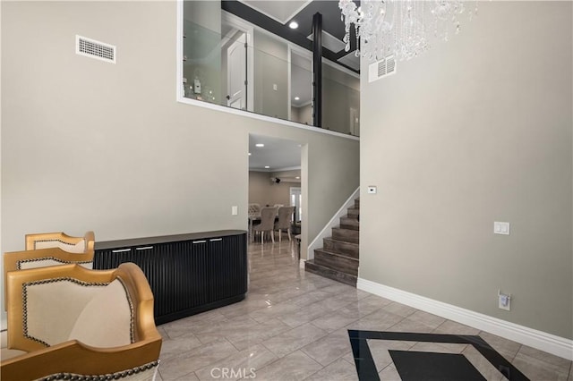 entryway with stairway, baseboards, visible vents, and a chandelier