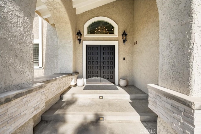 doorway to property featuring stucco siding